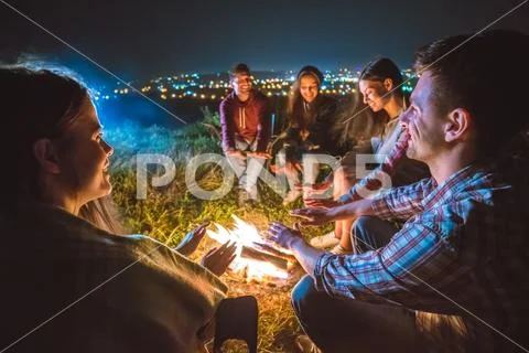 The five people warming hands near the bonfire. night time Stock Photos