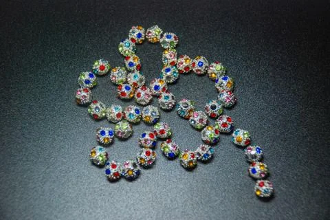 Five petals flower shape assembled with silver crystal beads of green, blue,  Stock Photos