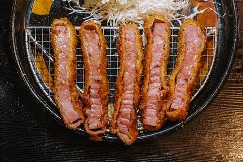 Five pieces of grilled medium rare beef katsu in the grill pan Stock Photos