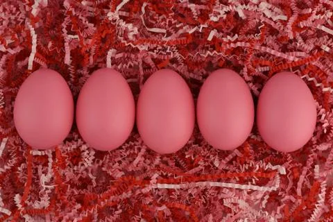 Five pink Easter eggs in a row on striped paper in red and pink tones Stock Photos