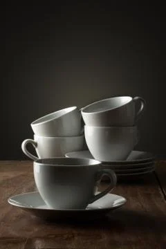 Five plain white ceramic coffee or tea cups Stock Photos