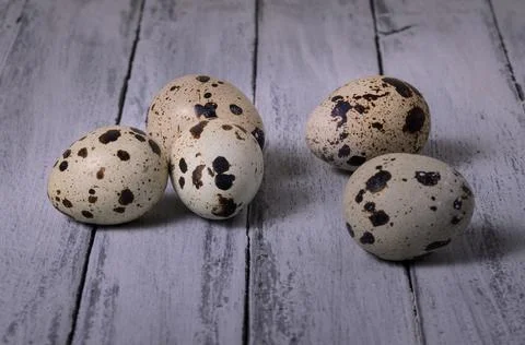 Five quail eggs on an old painted wooden table Stock Photos