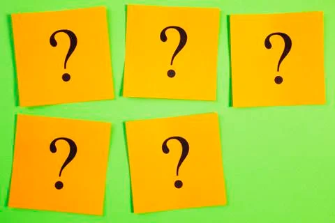 Five question marks on orange on green background Stock Photos