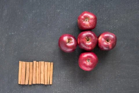 Five red apples and cinnamon in row Stock Photos