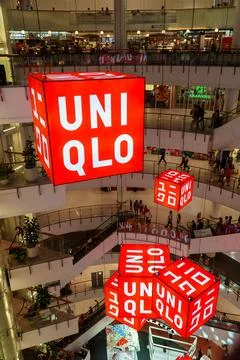 Five red cubes with white Uniqlo letters were hung in the mall. Fotos Stock
