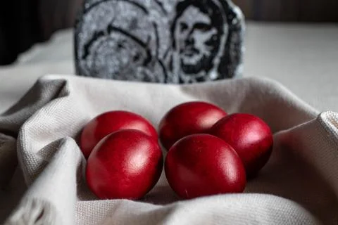 Five red-dyed Easter eggs, placed in a basket with a cream cotton napkin Stock Photos