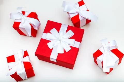 Five red gift boxes with ribbons on a white table, Christmas. Stock Photos