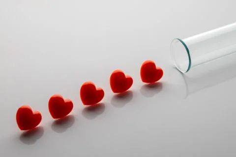 Five red hearts in a row like drops of blood from a test tube. The concept of Stock Photos