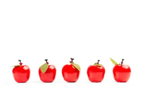 Five red plastic apples on a white background Foto stock