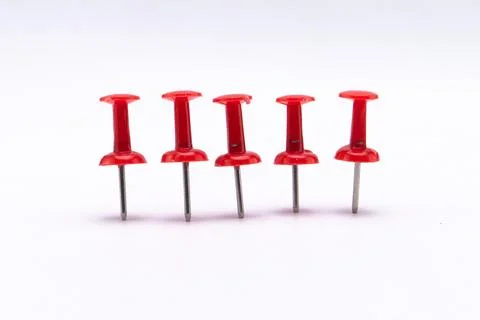 Five Red Push Pins Standing in a Row on White Background. Stock Photos