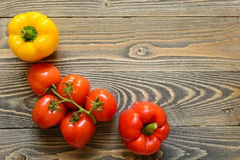 Five red tomatoes and red pepper on a wooden background Stock Photos