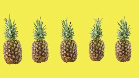 Five ripe fresh pineapples on yellow background Stock Footage 157116956
