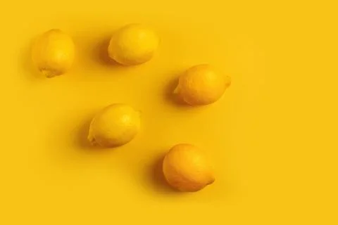 Five ripe lemons on a yellow background. Stock Photos