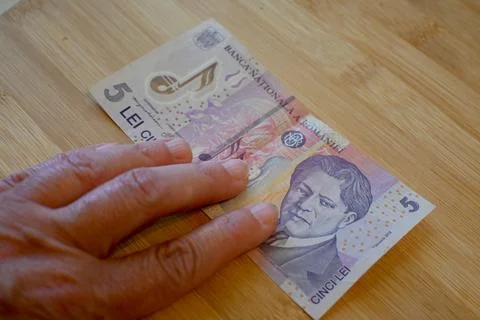 Five Romanian Leu Banknotes in Hand, Financial Struggle Concept Photos