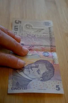 Five Romanian Leu Banknotes in Hand, Financial Struggle Concept Photos