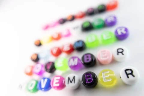 Five rows of colorful alphabet beads spelling out the calendar month. Stock Photos