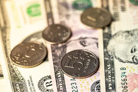Five-ruble coin on the background of dollar bills. Stock Photos