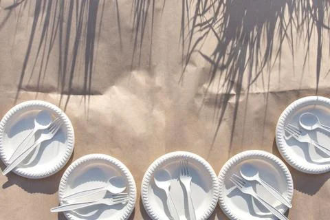 Five sets of disposable biodegradable glassware on craft paper in nature. Stock Photos