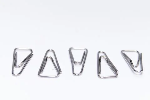 Five Silver Paper Clips in a Row on White Background, Office Supplies, Mini.. Stock Photos