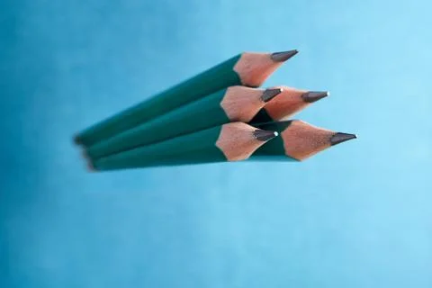 Five simple lead pencils with sharp sharpening, on blue background. Stockfoto's