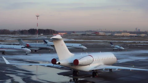 Five small and medium-sized business jets parked at the airport. Winter snow. 4K Stock Footage 115656273