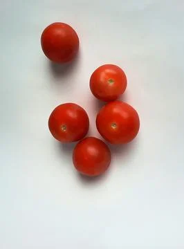 Five small ripe red tomatoes on a white background Stock Photos