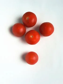 Five small ripe red tomatoes on a white background. Stock Photos
