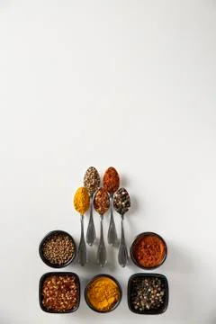 Five small spoons and five bowl with Spices in them Stock Photos