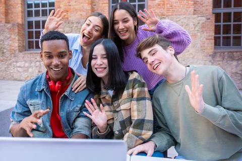 Five smiling multiracial friends make a video call on a laptop. Stock Photos