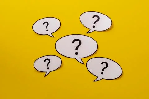 Five speech bubbles with question marks over a bright yellow background Stock Photos