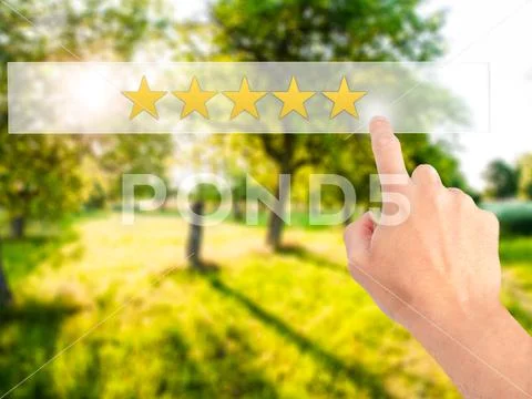 Five star rating - Hand pressing a button on blurred background Stock Photos