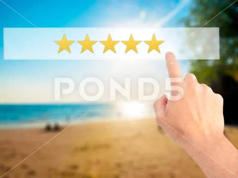Five star rating - Hand pressing a button on blurred background Stock Photos