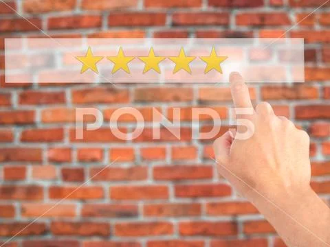 Five star rating - Hand pressing a button on blurred background Stock Photos