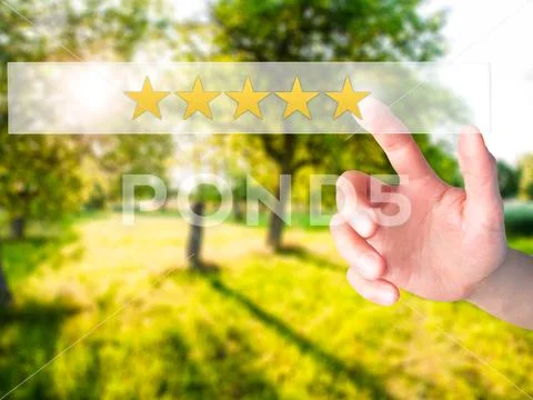 Five star rating - Hand pressing a button on blurred background Stock Photos