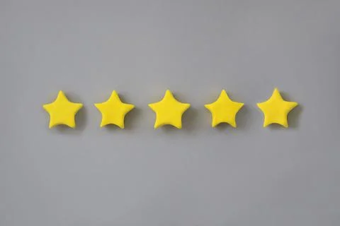 Five star in a row on grey background. Golden star shape. Concept of top Stock Photos