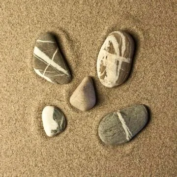 Five stones in the sand Stock Photos