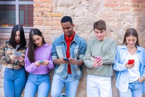 Five students having fun with mobile phones creating content on social media. Stock Photos