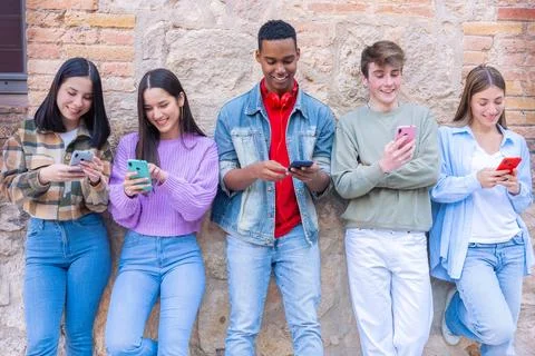 Five students having fun with mobile phones creating content on social media. Stock Photos
