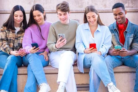 Five students having fun with mobile phones creating content on social media. Stock Photos