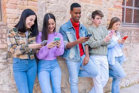 Five students having fun with mobile phones creating content on social media. Stock-Fotos