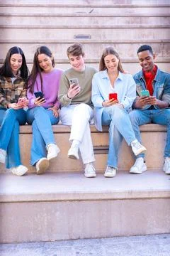 Five students having fun with mobile phones creating content on social media. Stock Photos