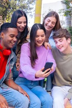 Five students having fun with mobile phones creating content on social media. Stock Photos
