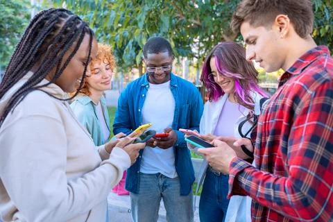 Five students having fun with mobile phones creating content on social media. Stock Photos