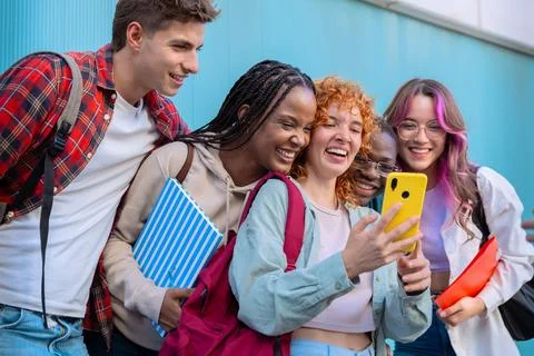 Five students having fun with mobile phones creating content on social media. Stock Photos