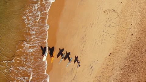 Five Surfers Walking Along the Beach at Sunrise, Aerial Drone View, 4K Stock Footage 340968125
