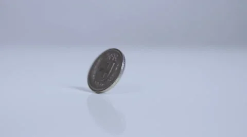 Five swiss franc coin rolling on white surface, slow motion Stock Footage 58761259