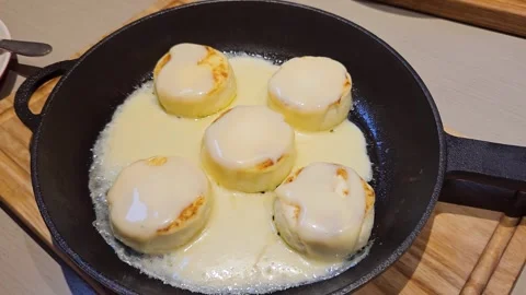 Five tender cheesecakes in butter cream in a cast-iron skillet. 스톡 동영상 243189526