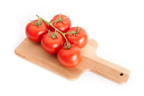 Five tomatoes on kitchen board Stock Photos
