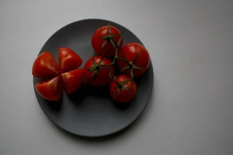 Five tomatoes on plate from above Stock Photos