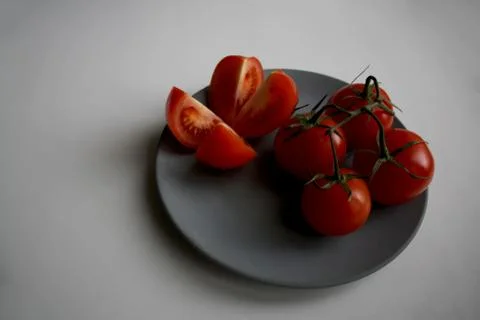 Five tomatoes on plate Stock Photos